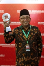 Lis Darmansyah menunjukkan piala