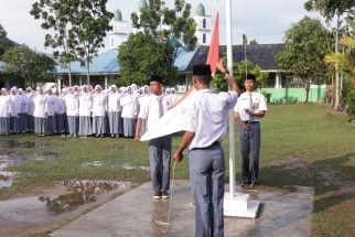 Meskipun lapangan tergenang air para siswa tetap menggelar upacara