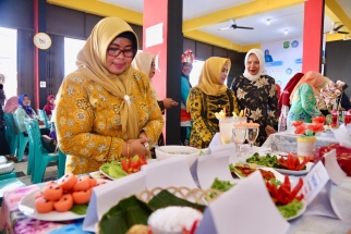 Juwariyah mengecek makanan non beras hasil olahan PKK